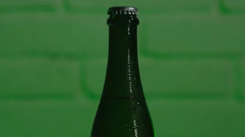Close-up of the neck of a green beer bottle with a closed lid with a changing Stock Footage 185191037