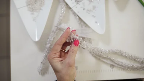 Close-up of needle and thread and hands of tailor holding a pattern and Stock Footage 121505809