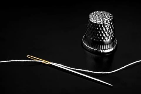 Close up of a needle eye with white thread Stock Photos