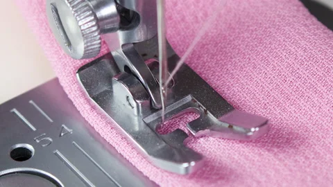 Close up of needle moving and sewing on sewing machine. Sewing pink material 스톡 동영상 137545596
