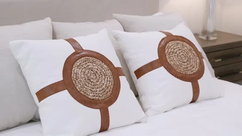 Close up of new bed comforter with decorative soft pillows of white-brown design Stock Footage 245770501
