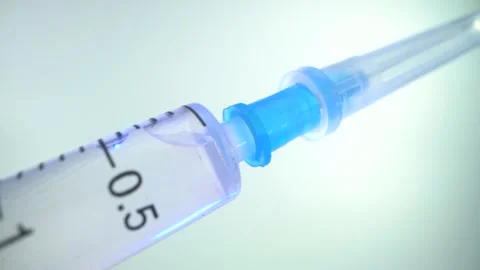 Close-up of a new disposable syringe with a closed cap on a needle. The medicine Stock Footage 143535867