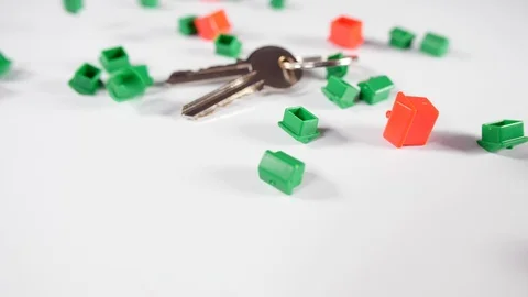 Close up of new door keys with red and green game house playing board game piece Stock Footage 89188833