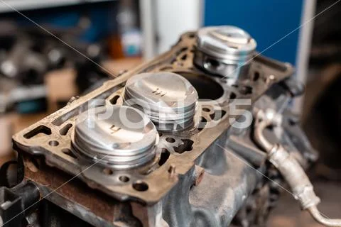 Close-up a new pistons for the engine, overhaul.. Engine on a repair stand with Stock Photos