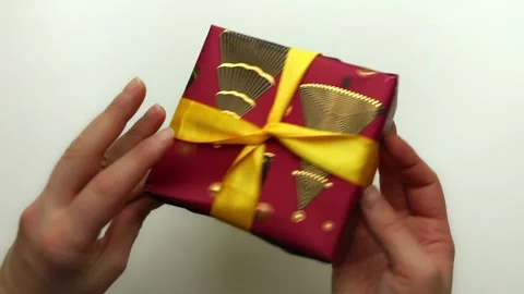 Close-up of a New Year's gift. Hands take the gift in hand and examine it from Stock Footage 145150840