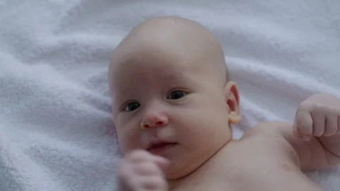 Close-up, newborn baby lying in bed wrapped in a towel, after bathing Stock Footage 306005472