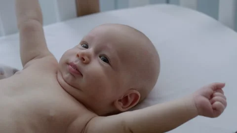 Close-up, newborn baby lying in bed stretching arms Stock Footage 306044581