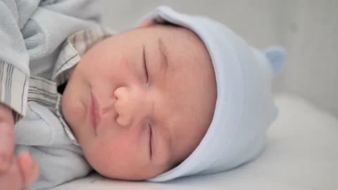 Close-up of a newborn baby lying down, sleeping on a white blanket Stock Footage 231873331