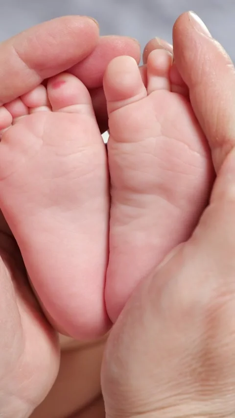 Close up of newborn babys tiny bare feet gently held in mothers hands Stock-Footage 341285661
