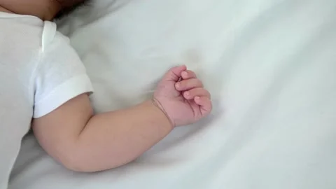 Close up of newborn boy hand on white sheet background. Baby sleeping on the bed Stock Footage 202191564