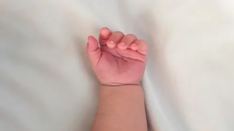 Close up of newborn boy hand on white sheet background. Baby sleeping on the bed Stock Footage 202285902