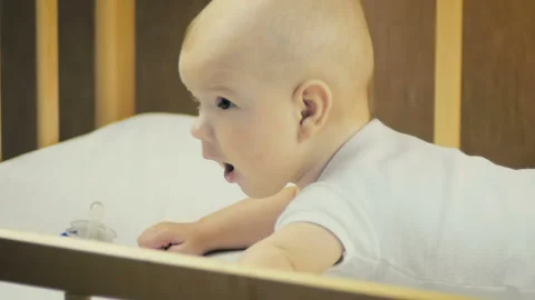 Close-up of a newborn boy lying on his stomach in bed in slow motion. Stock Footage 98581516