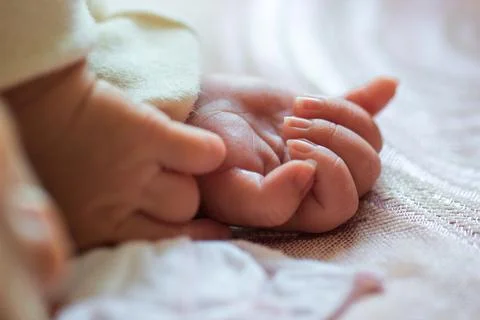 Close-up of newborn tiny feet resting gently on soft textile fabric Stock Photos