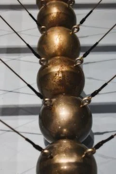 Close-up of a Newton's cradle made up of a row of large copper balls Stock Photos