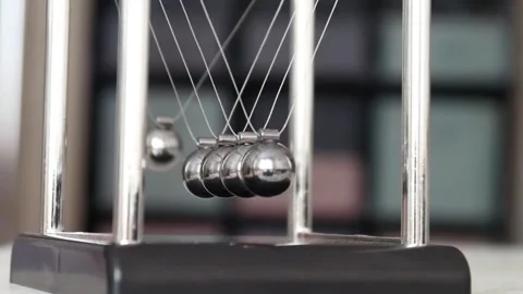 Close-up of Newton's cradle on the table and a child's fingers pulling back one Video stock 260954665