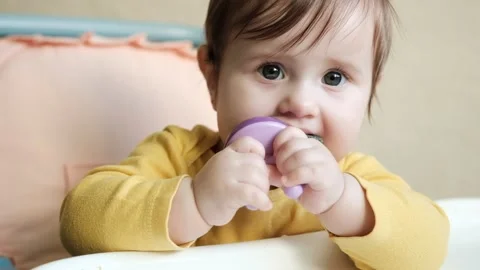 Close up nice baby age of 9-10 months eats fruits by using nibbler Stock Footage 144630306