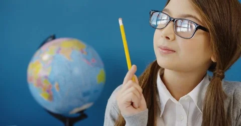 Close up of the nice schoolgirl in glasses doing her homework at the desk and an Stock Footage 82918891