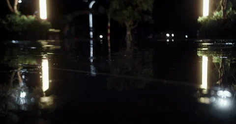 Close-up at night, drops of summer or autumn rain fall on the asphalt in the Stock Footage 242886375