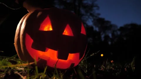 Close-up at night lighting a fire inside a Halloween pumpkin. 스톡 동영상 253311427