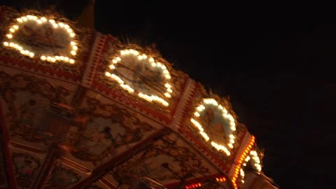 Close-Up Night Shot of an Ornate Carousel in Motion with Bright Lights Against a Stock Footage 278731913