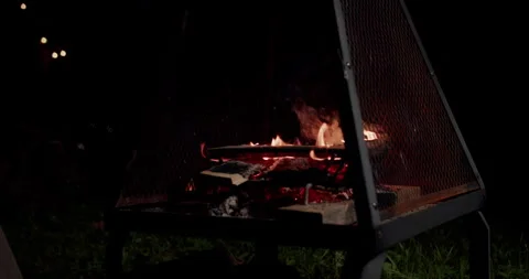 Close up Night time campfire burning in a dark metal fire pit Stock Footage 247785435