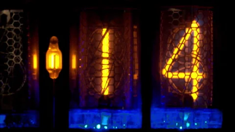 Close-up of Nixie tube digital display reads :14 and changes to :15. Stock Footage 278438838