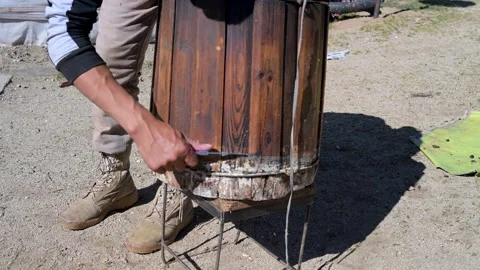 Close-up of a Nomad Man Cleaning a Rustic Wooden Barrel. A Scene of Traditional Stock Footage 317133472