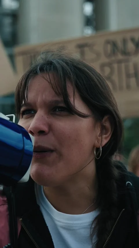 Close up nonconformist gen z activist woman shouting at protest megaphone Stock Footage 263145820