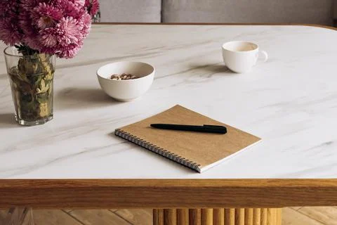Close-up of a notebook and pen on a kitchen table, planning and organization. Stock Photos