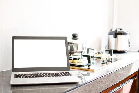 Close up, A notebook computer white screen on the kitchen counter. Has a po.. Stock Photos