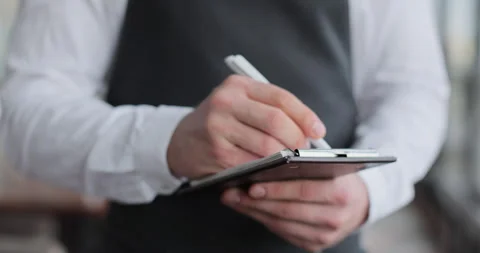 Close-up of a notebook in the hands of a waiter. Stock Footage 318970753