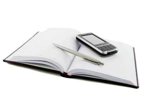 Close up notebook, pen and mobile phone on it isolated over white Stock-Fotos