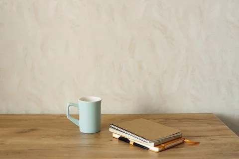 Close-up of notebooks and a cup on a table, cozy workspace, copy space. Stock Photos