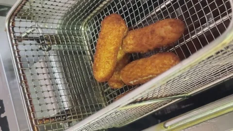 Close-up of nuggets in deep-frying nets in the restaurant's industrial kitchen Stock Footage 262938253
