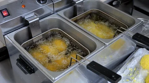 Close-up of nuggets or cutlets fried in boiling oil in a professional kitchen. Stock Footage 318659969