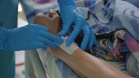 Close-up. The nurse completes the installation of a dropper catheter.4K Stock Footage 94723169