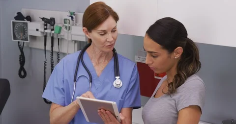 Close up of nurse explaining to young hispanic patient her health condition Stock Footage