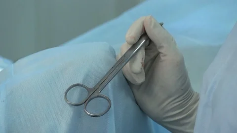 Close-up of a nurse's hand with clean scissors and clamps. during the operation. Stock Footage 125817156