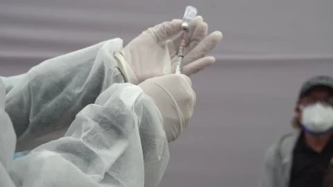 Close-up of a nurse's white-gloved hands taking out the covid-19 vaccine with a Stock Footage 156306962