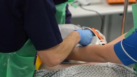 Close-up of nurses’s hands. Training on real person, learning how to use an Stock Footage 92235804
