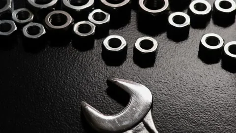 Close-up nuts and wrench on dark background with light effects Stock Footage 190896514