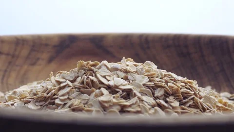 Close up oat flakes falling into bowl Stock Footage 97937123