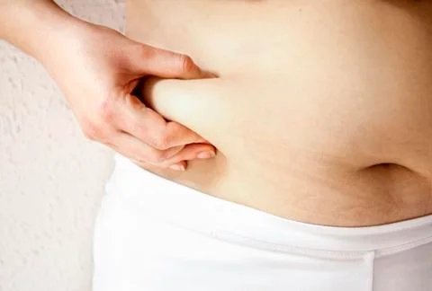 Close up of a obese  young lady checking her fats 库存照片