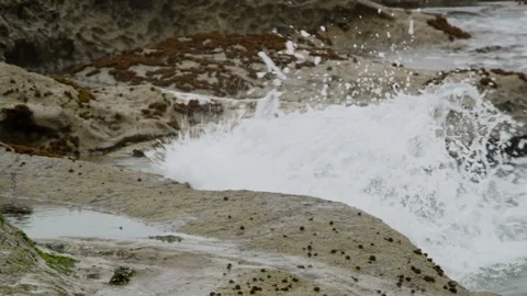Close up of ocean waves crashing into rocks on a cloudy day 库存影片 119041842