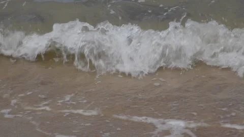 Close-up ocean waves lapping and make white foam on the shore. Stock Footage 132858904