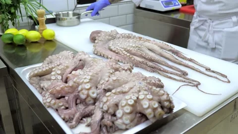 Close-up of an octopus. A chef in blue gloves is beating an octopus with a Stock Footage 167242866