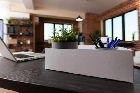 Close up of office decorations in box and laptop on desk Foto stock