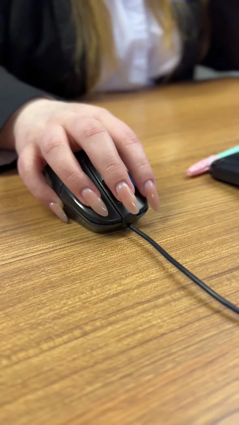 Close-up of an office workers hand with a black computer mouse on a brown desk Stock Footage 301145120