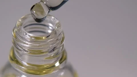 Close up oil drops falling from the pipette Stock Footage 152364325