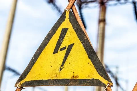 Close-up old aged rusty triangle metal plate with High voltage warning sign Stock Photos